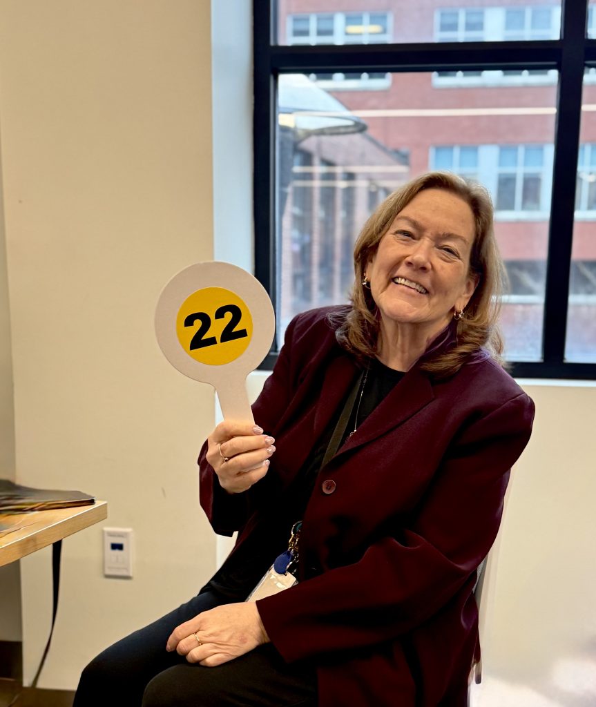 Photo of Dean and President Leigh Saufley holding auction paddle and smiling