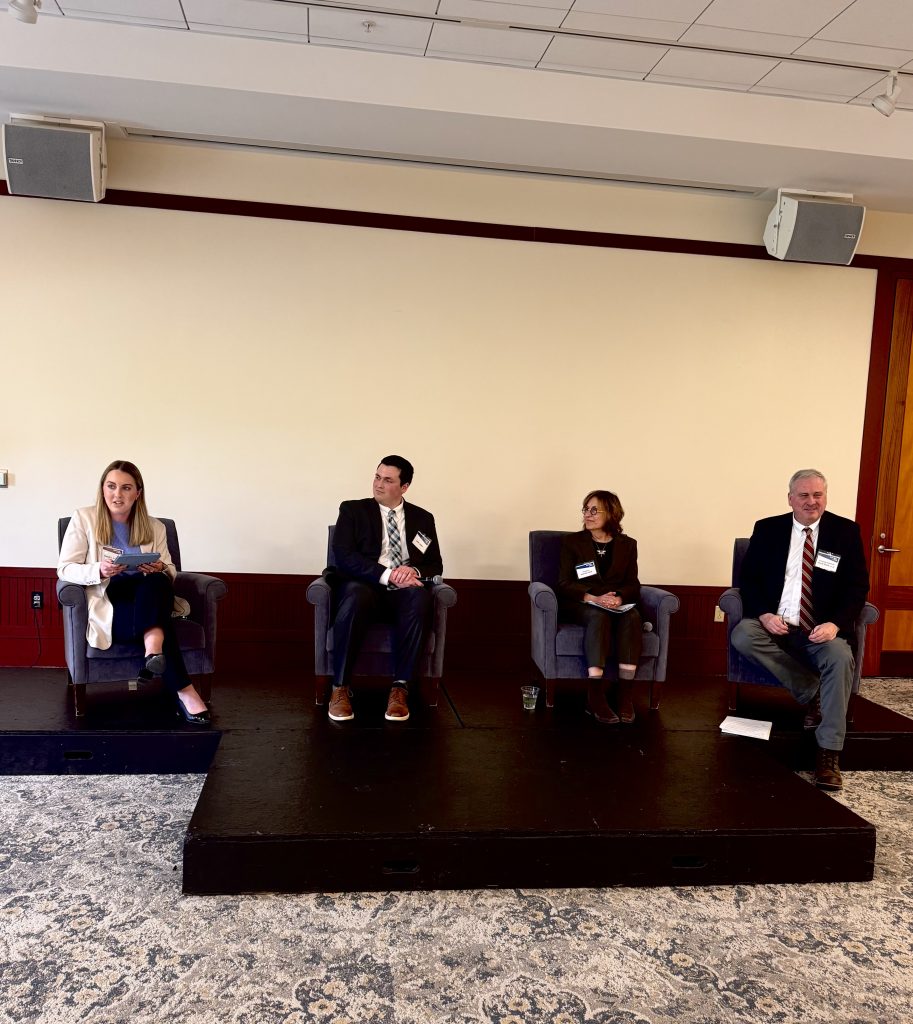 Four people seated on a stage 