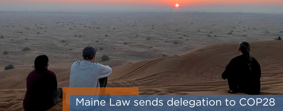 Photo of three Maine Law students in the desert outside Dubai. Headline reads: Maine Law sends delegation to COP28.