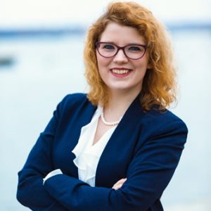 A portrait of Shianne Bowlin, arms crossed, wearing blouse and a blazer. 