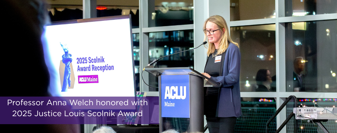 Anna Welch speaking into microphone Photo of Anna Welch in front of microphone at ACLU event
